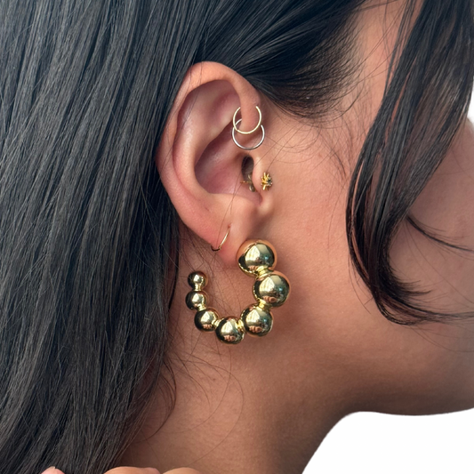 model wearing a gold-filled beaded ball c shaped hoop earring