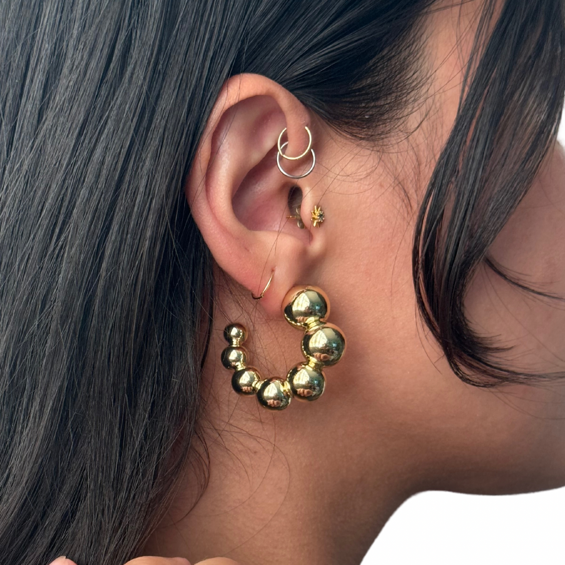 model wearing a gold-filled beaded ball c shaped hoop earring 