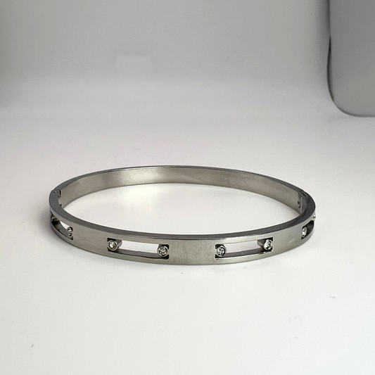 stainless steel silver sleek and dainty bangle. the design features cubic zirconia stones