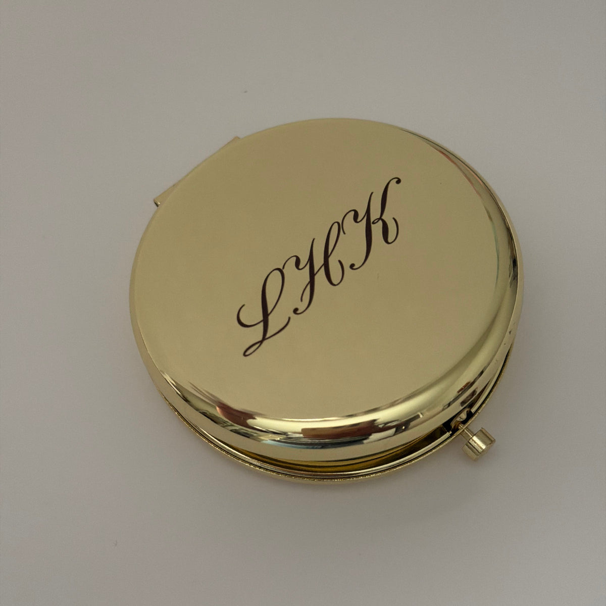 an engraved compact mirror with initials LHK