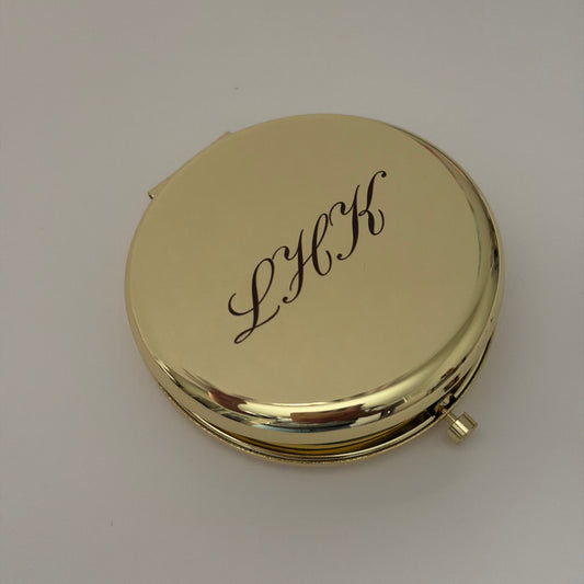 an engraved compact mirror with initials LHK
