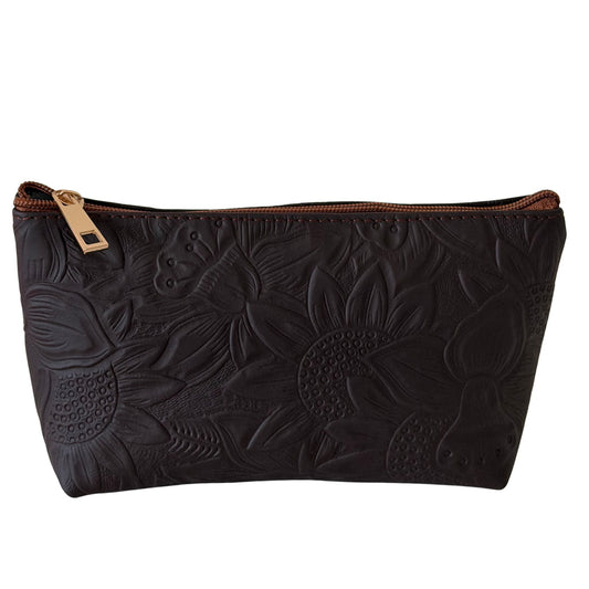 Black leather pouch with floral embossing and gold zipper on a white background