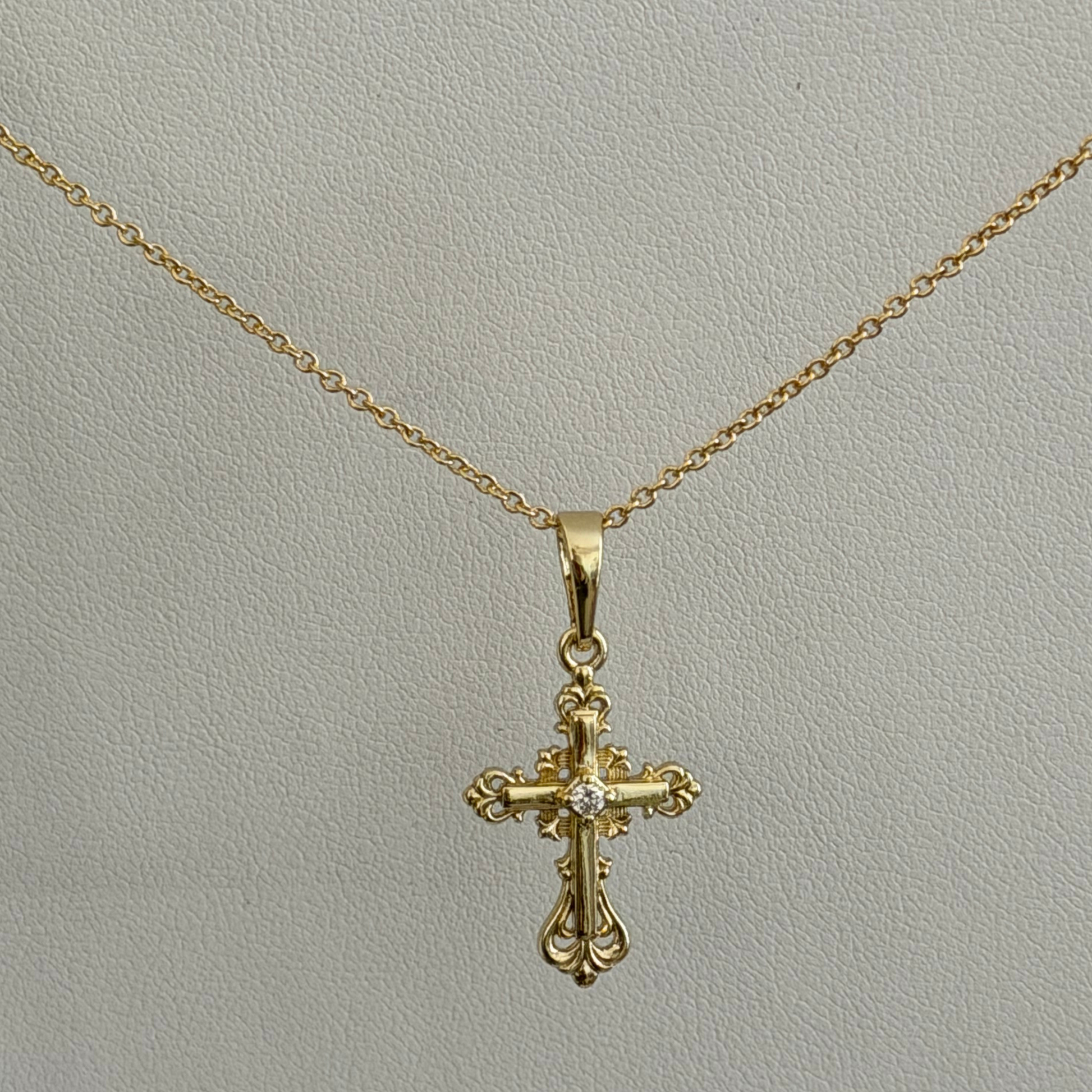 Close product shot of a vintage Catholic inspired cross pendant with a dainty chain 
