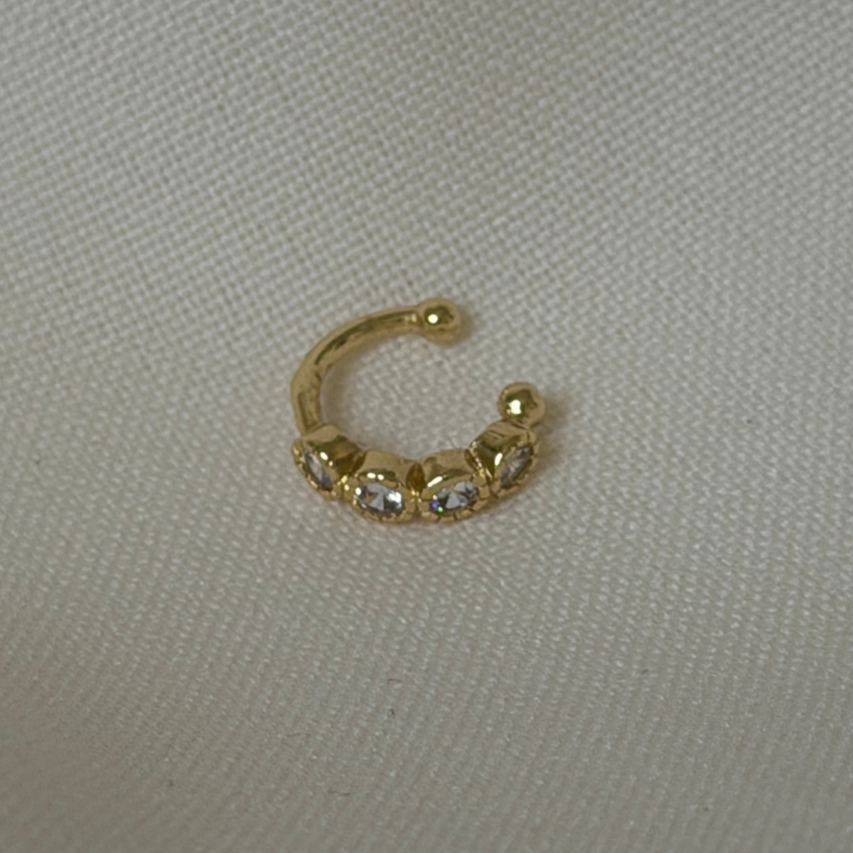 an ear cuff with round bezel cubic zirconia stones