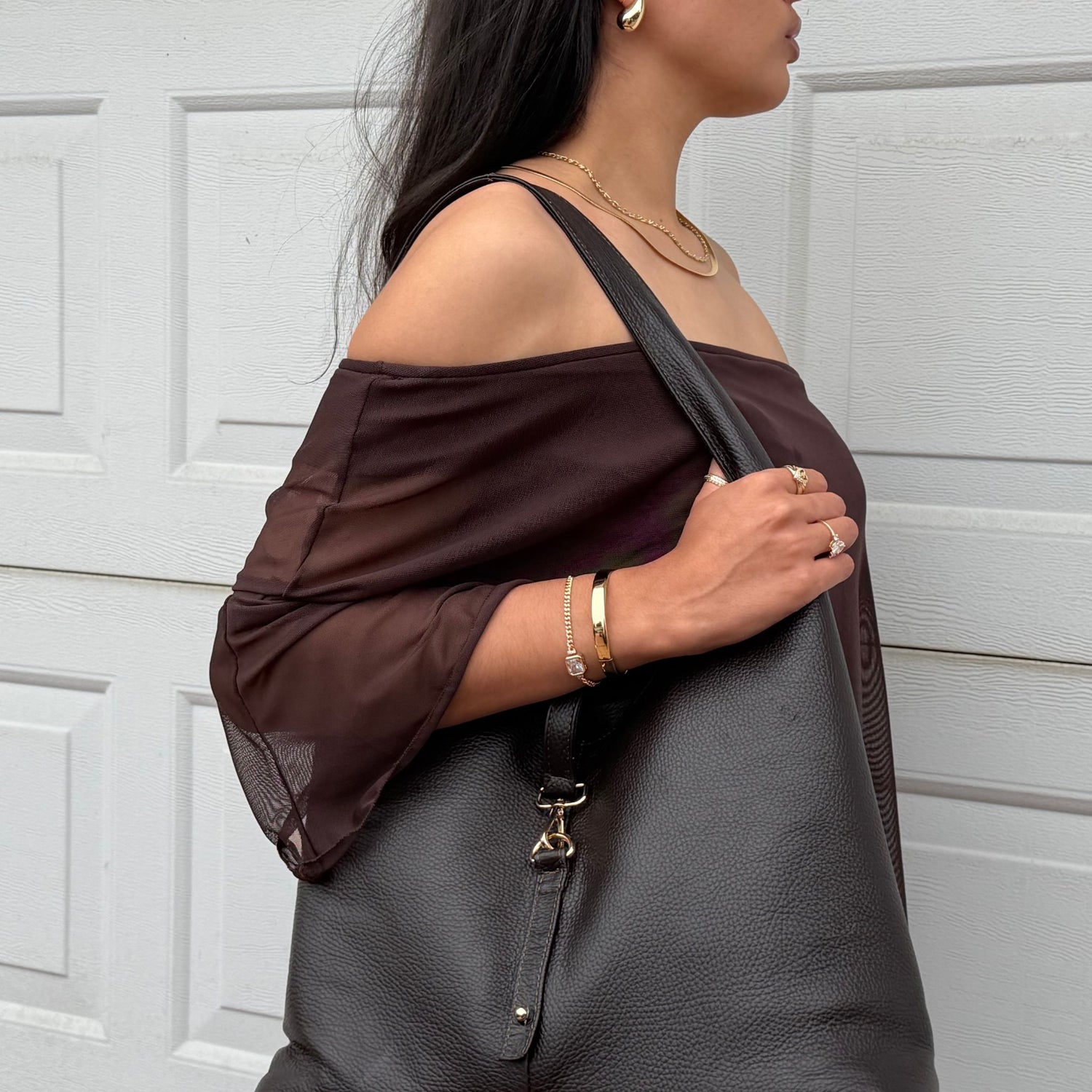 woman holding brown leather shoulder bag